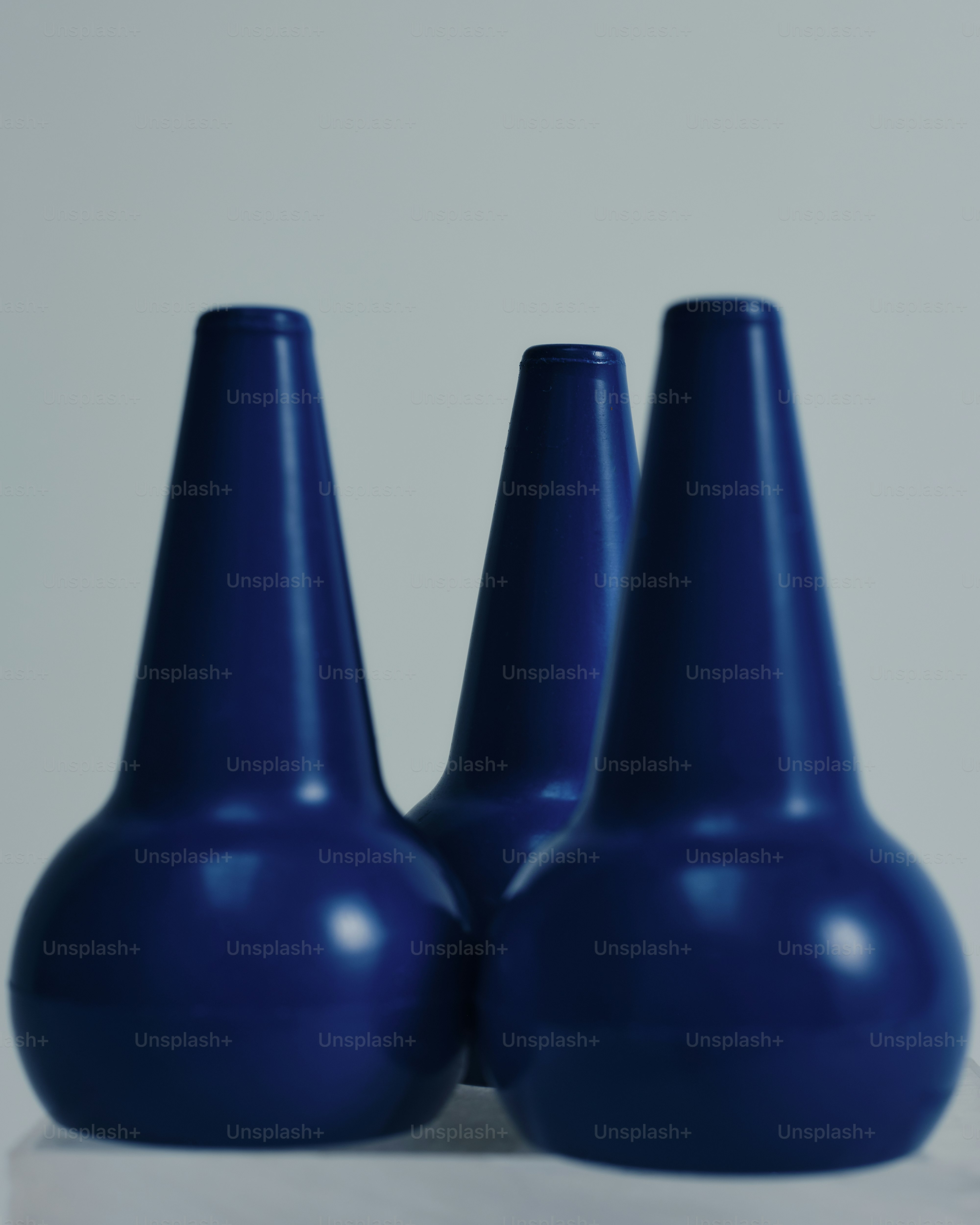 three blue vases sitting next to each other on a table