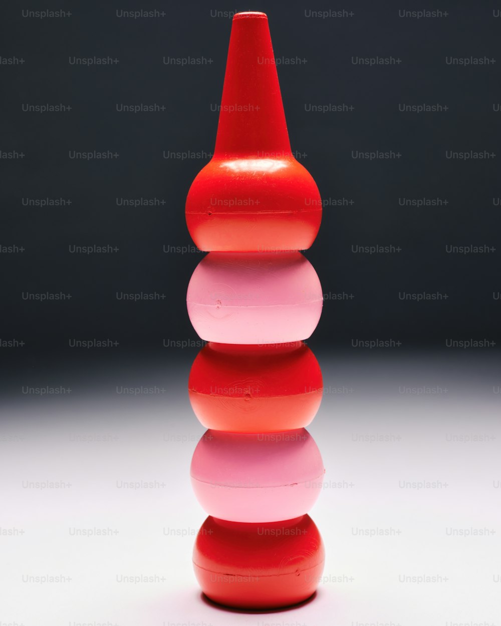 a red vase sitting on top of a white table