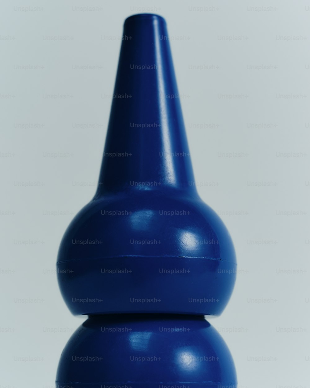 un vase bleu posé sur une table blanche