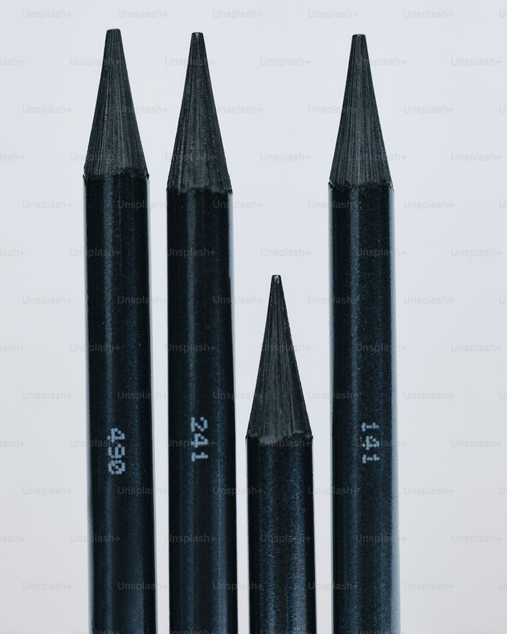 three black pencils sitting next to each other