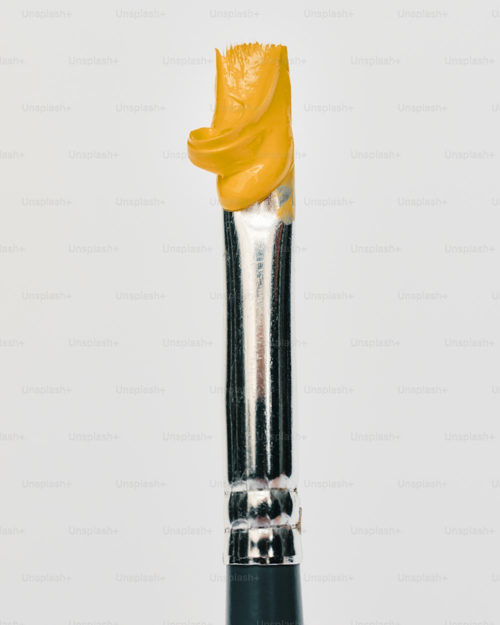 a close up of a yellow and black paint brush