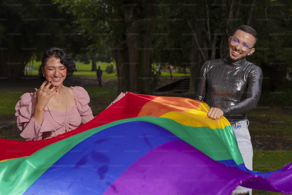 Un hombre y una mujer sosteniendo una cometa con los colores del arco iris