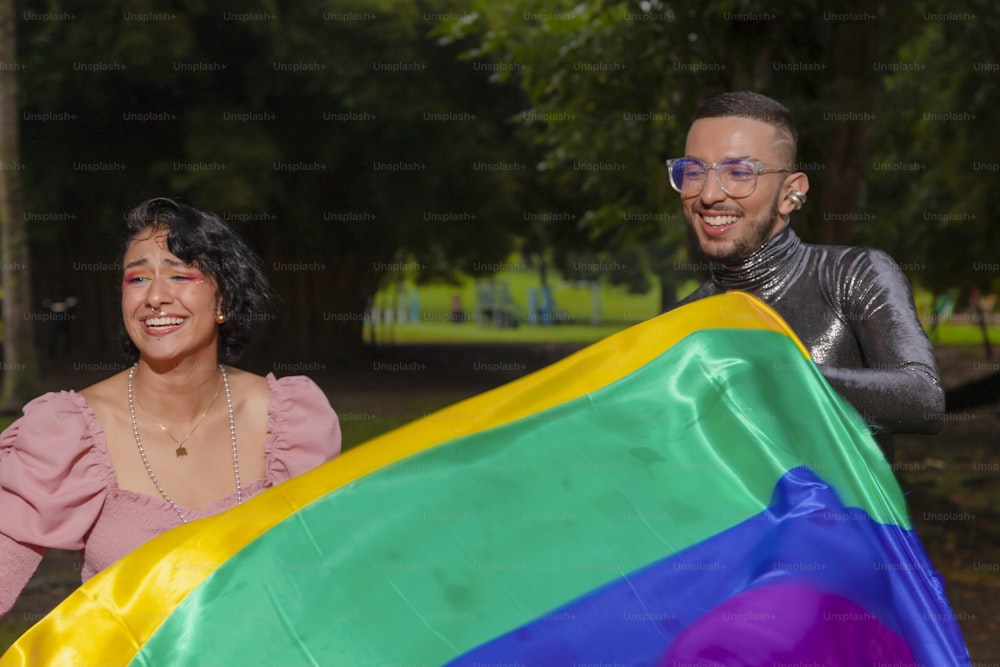 a man and a woman holding a rainbow flag