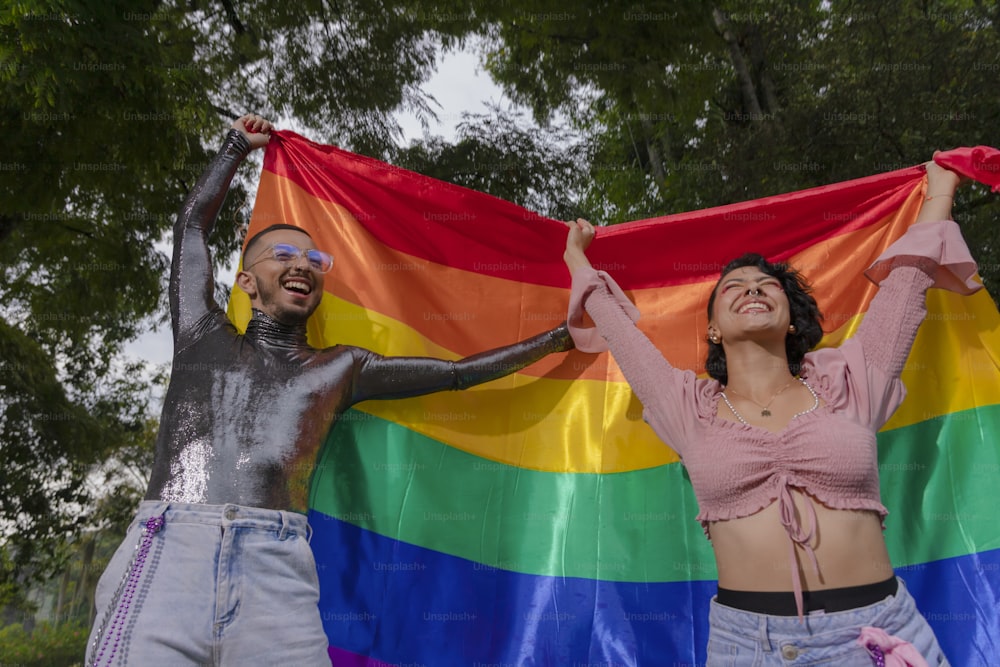 a couple of people that are holding a rainbow flag