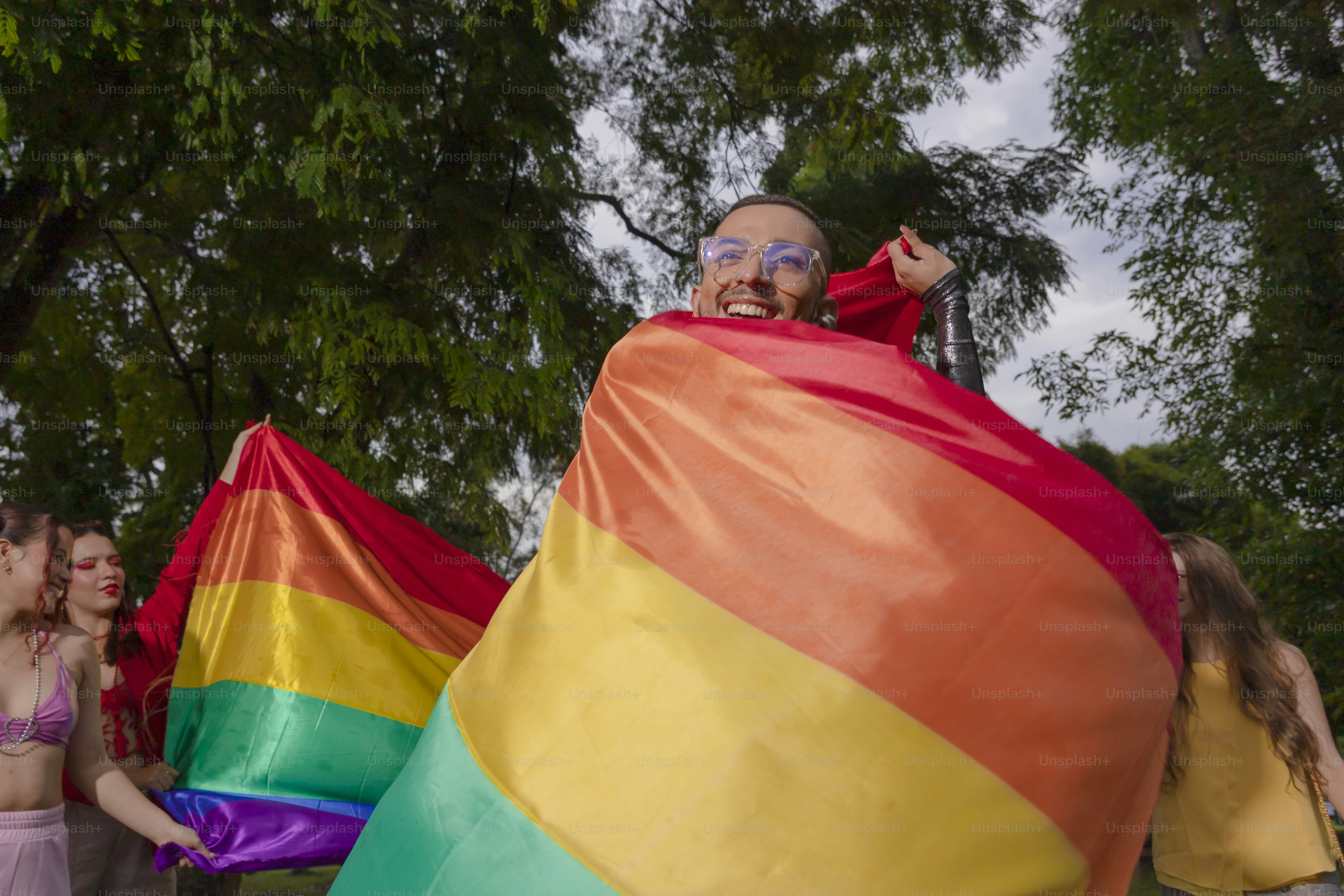 A group of people holding a rainbow flag photo – Self acceptance Image ...