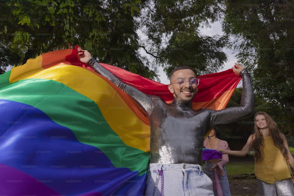 a man in a wet suit holding a rainbow flag