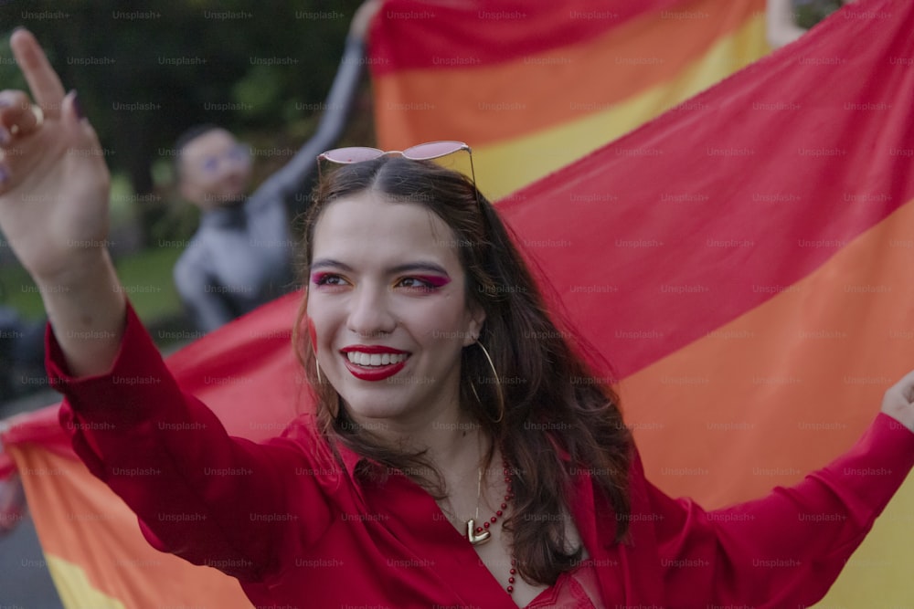 a woman in a red shirt holding a red and yellow flag