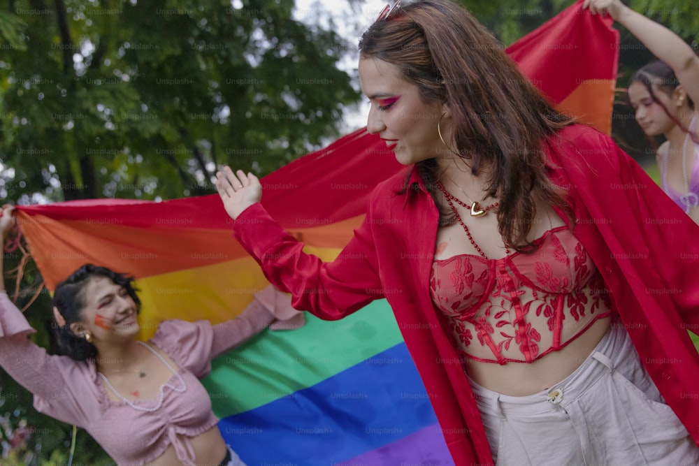 a group of women holding a rainbow flag
