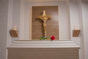 a cross and a rose on a mantle in a church