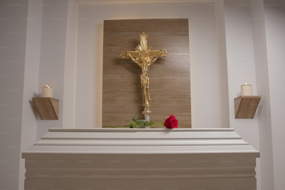 Une croix et une rose sur un manteau dans une église