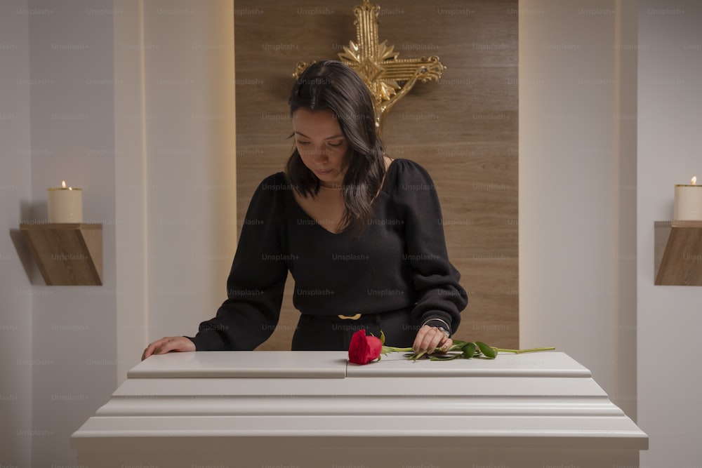 a woman arranging flowers on a table in a room
