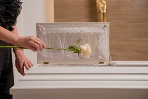 a woman is placing a rose in a box