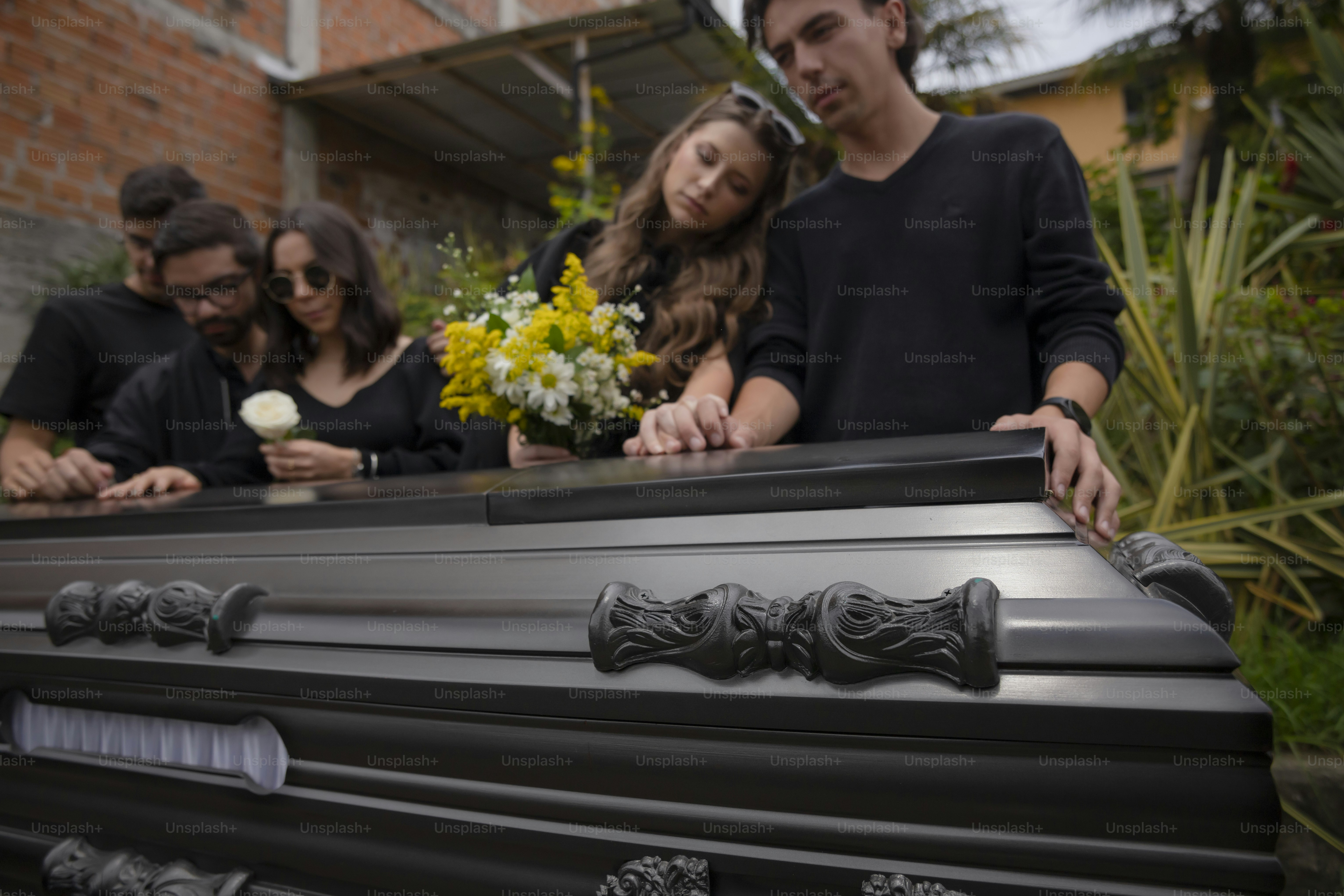 a group of people standing around a black piano
