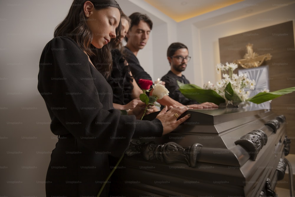 a group of people standing around a casket