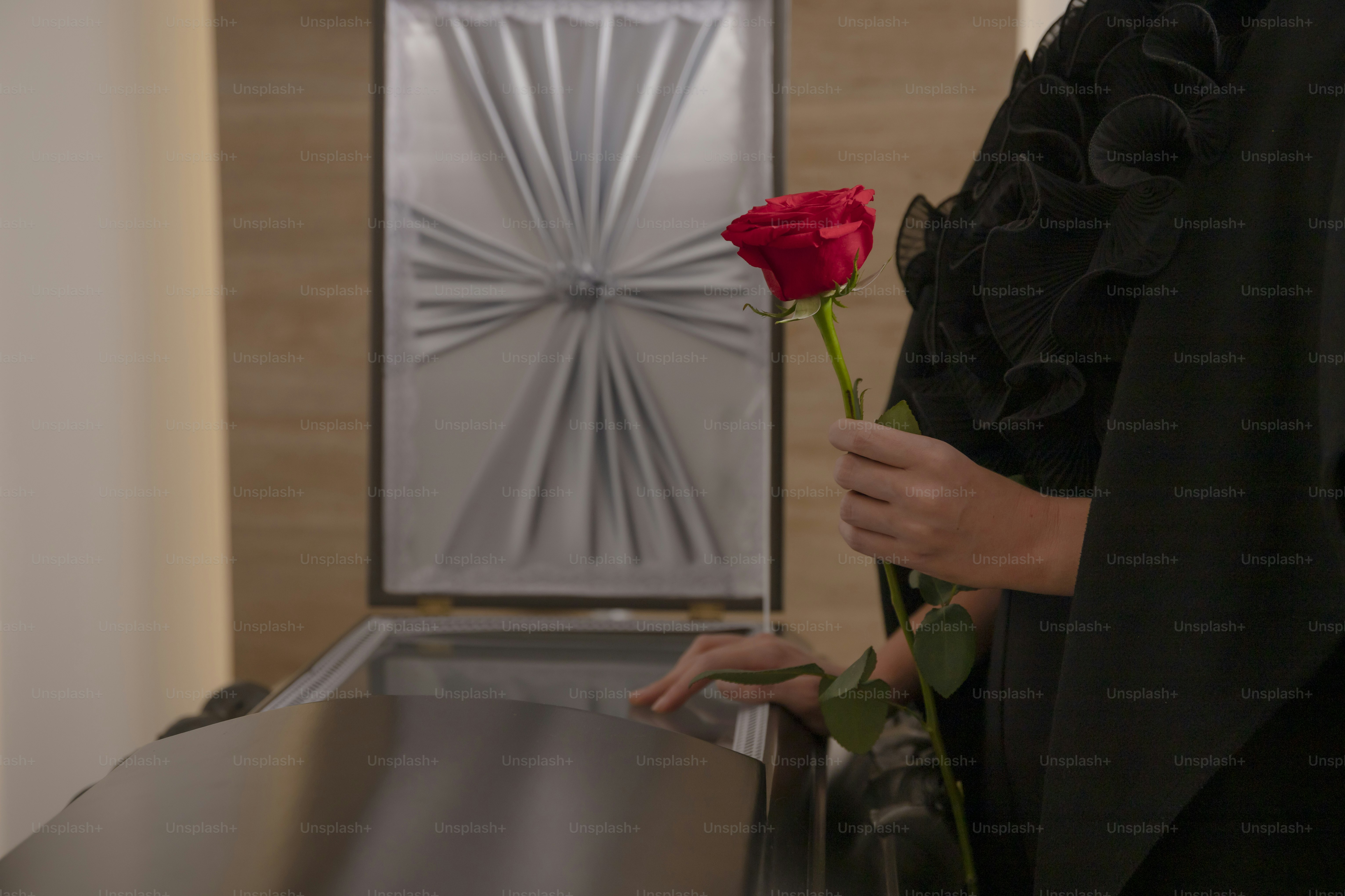 a woman is holding a rose in her hand