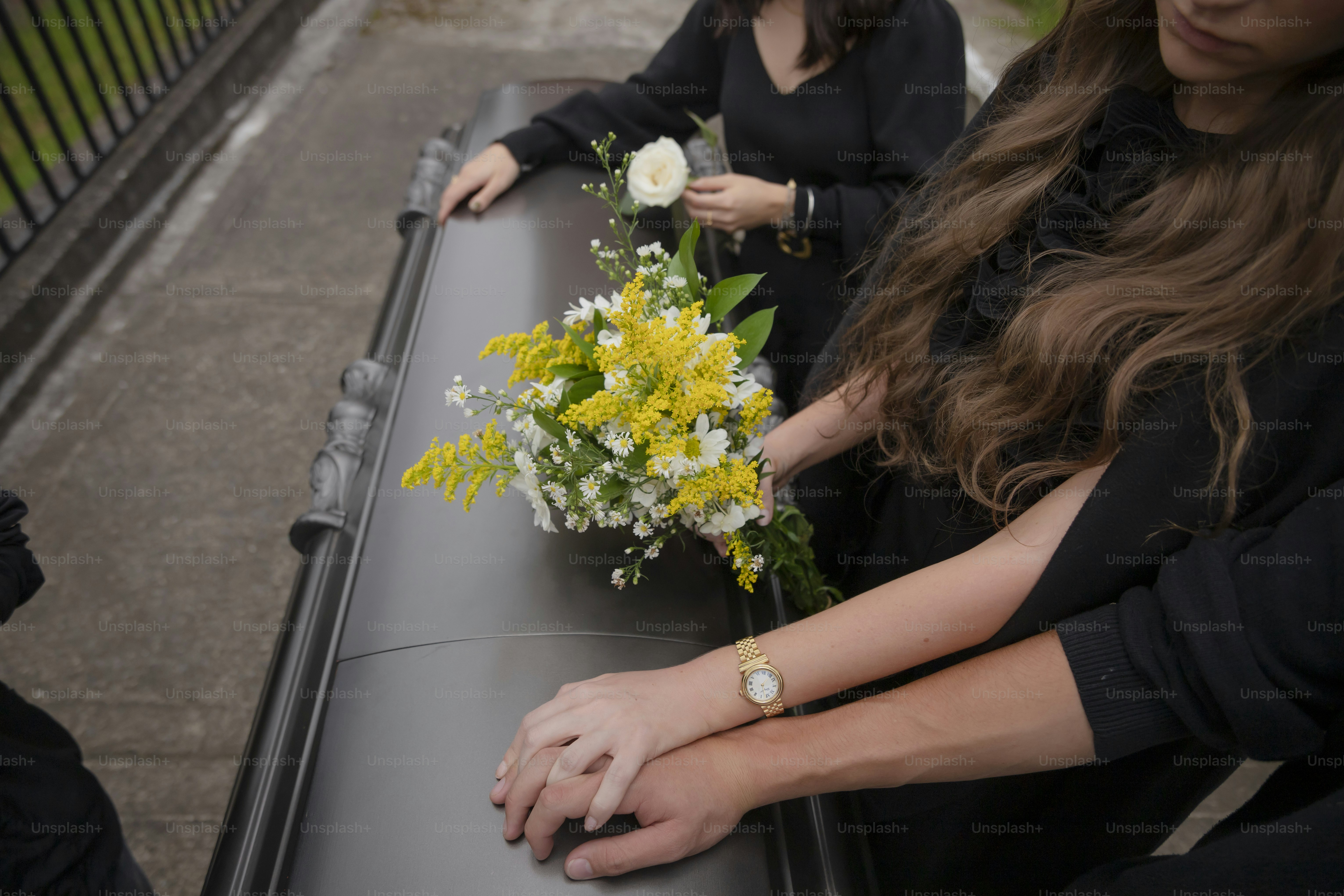 two women sitting at a table with a bouquet of flowers