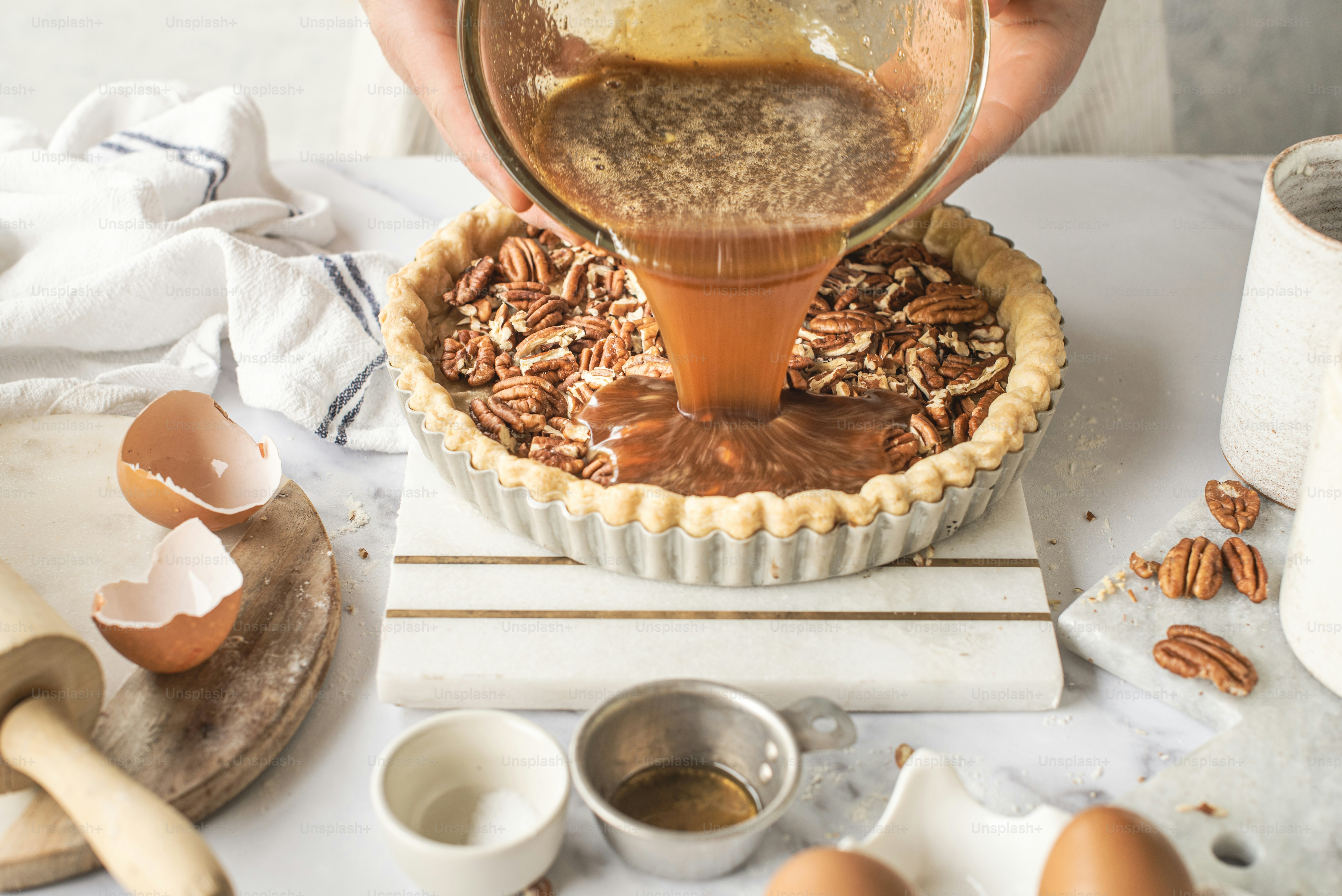 a person pouring syrup into a pie crust
