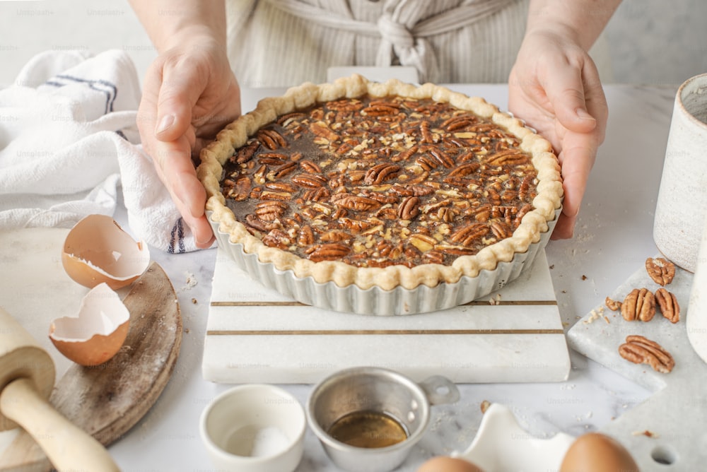 a person putting pecans on top of a pie
