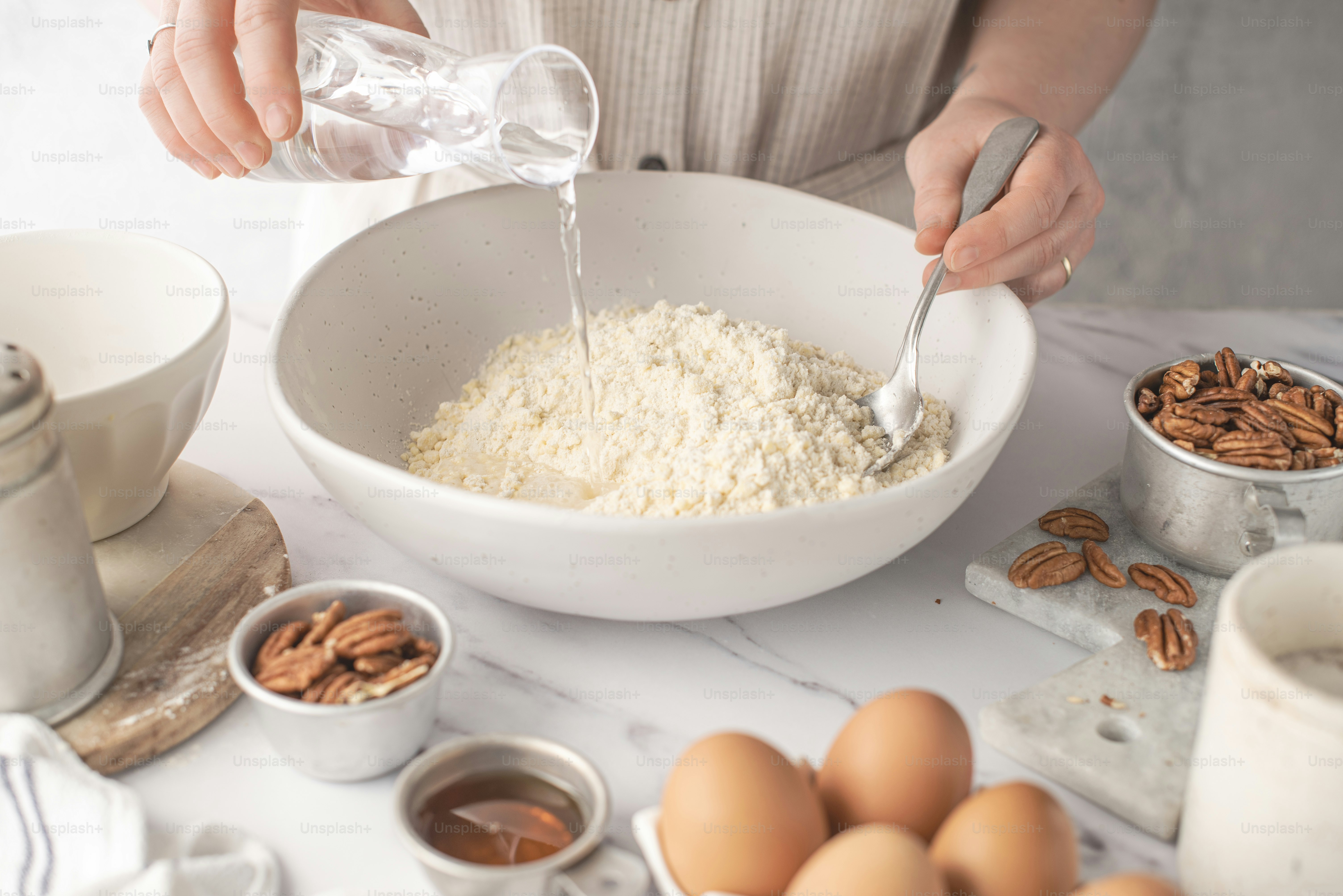a person pouring milk into a bowl of oatmeal
