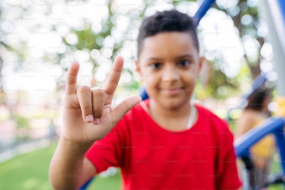 a young boy making the vulcan sign with his hand