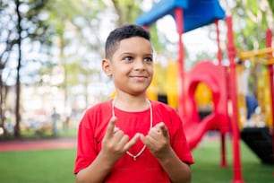 a young boy standing in front of a playground