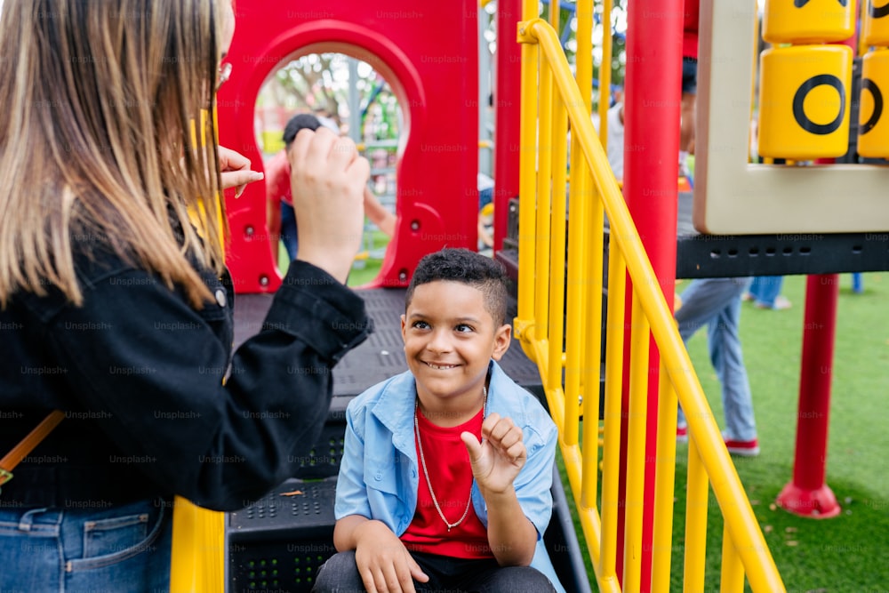 a woman taking a picture of a boy on a playground