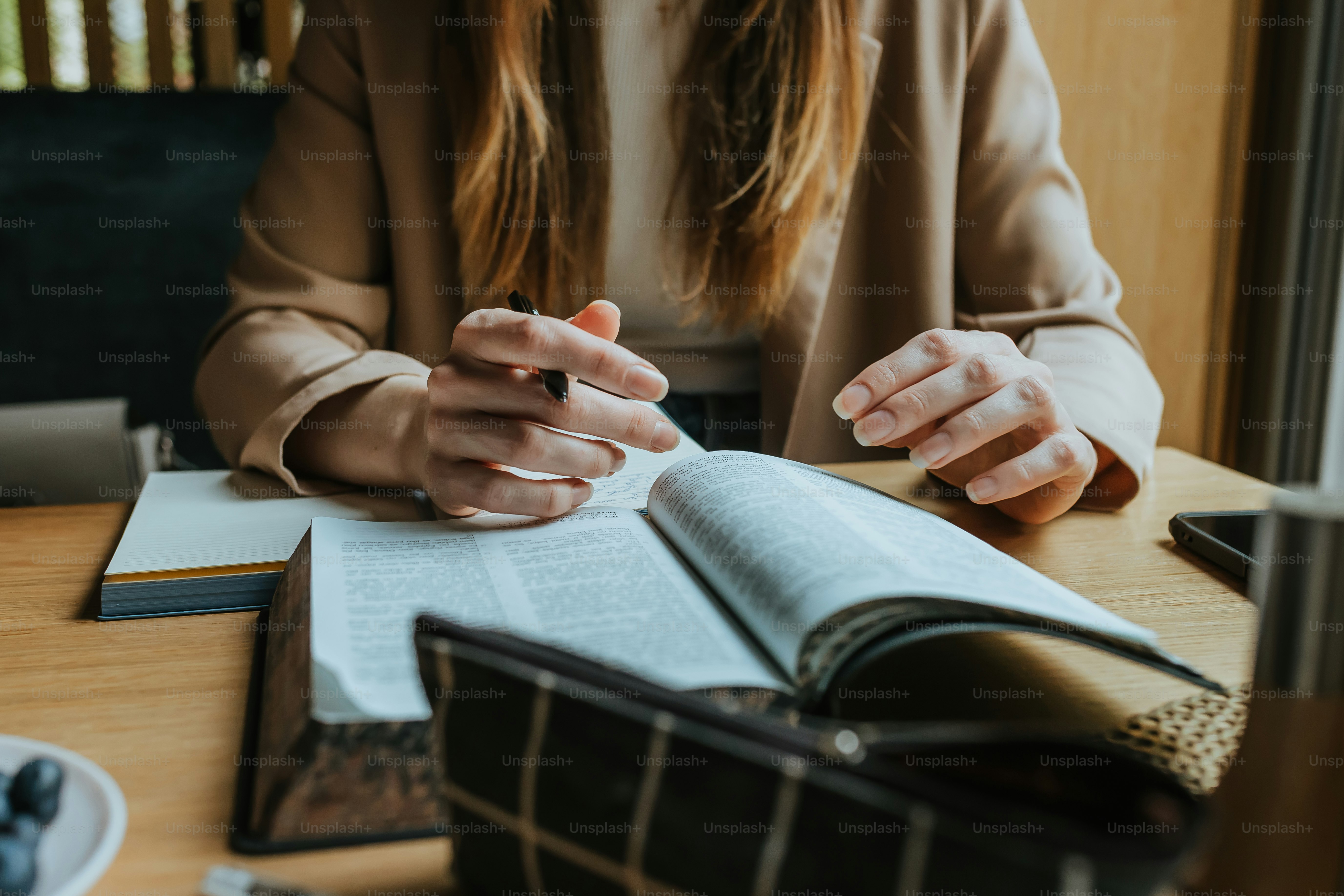 uma mulher sentada em uma mesa com um livro aberto