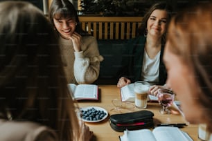 un gruppo di donne sedute intorno a un tavolo che parlano