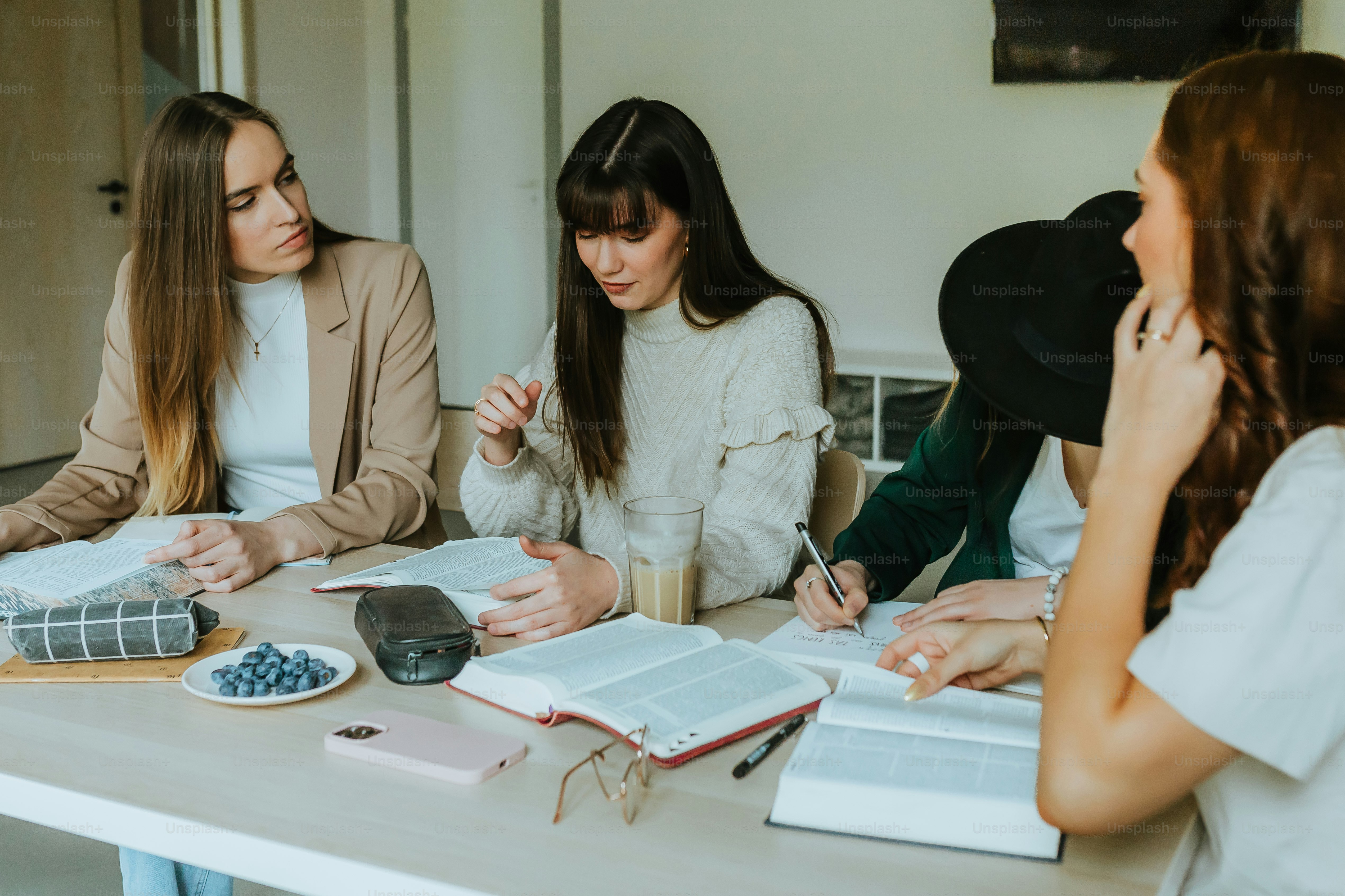 ノートを持ってテーブルを囲む女性たち