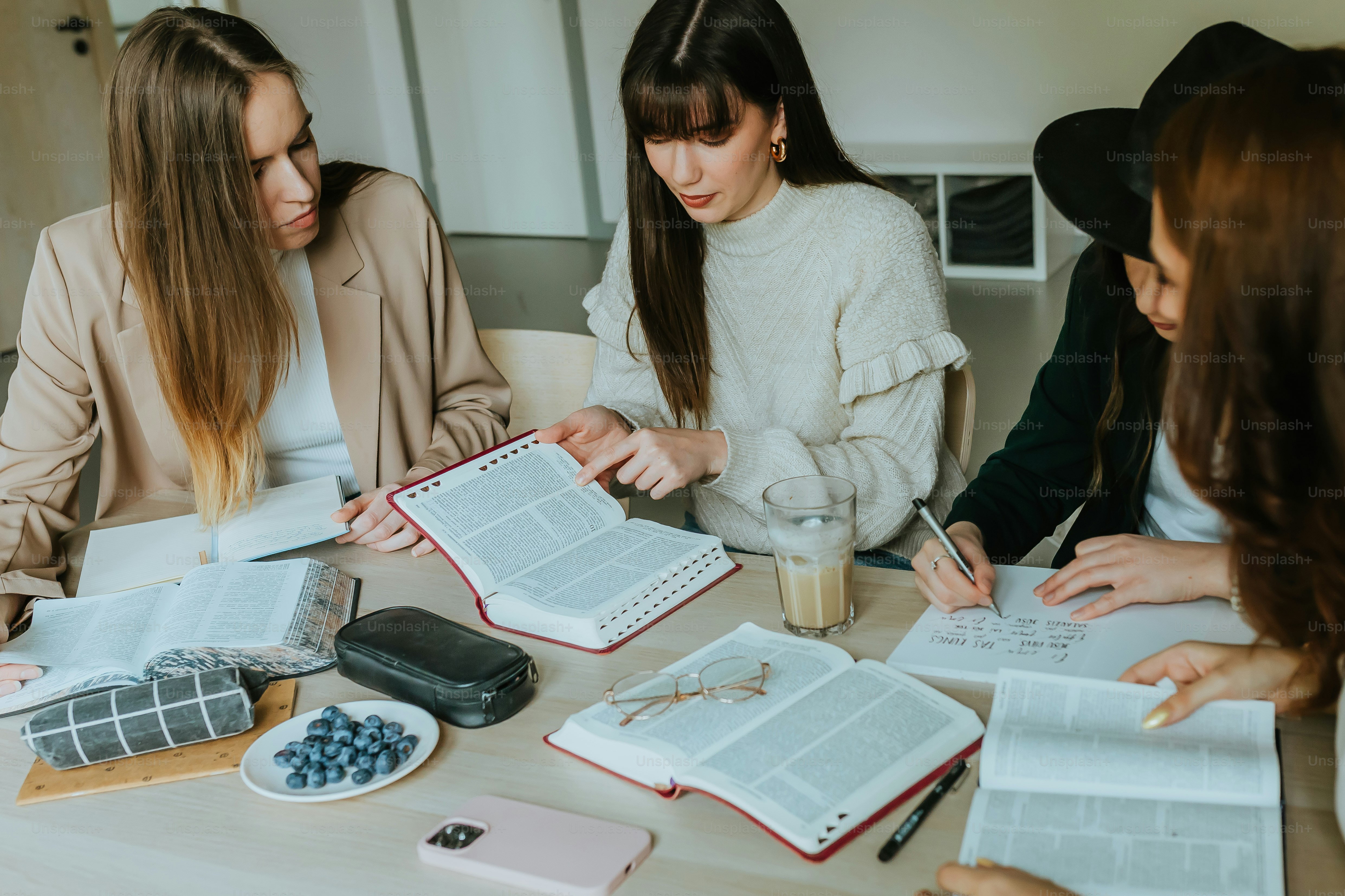 ノートを持ってテーブルを囲む女性たち