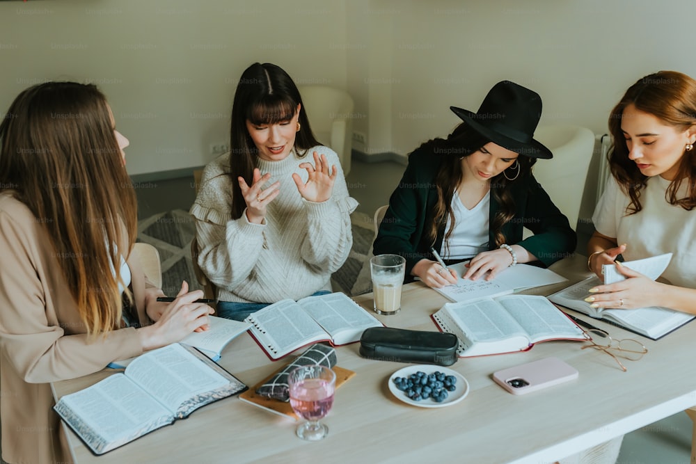 a group of women sitting around a table with books