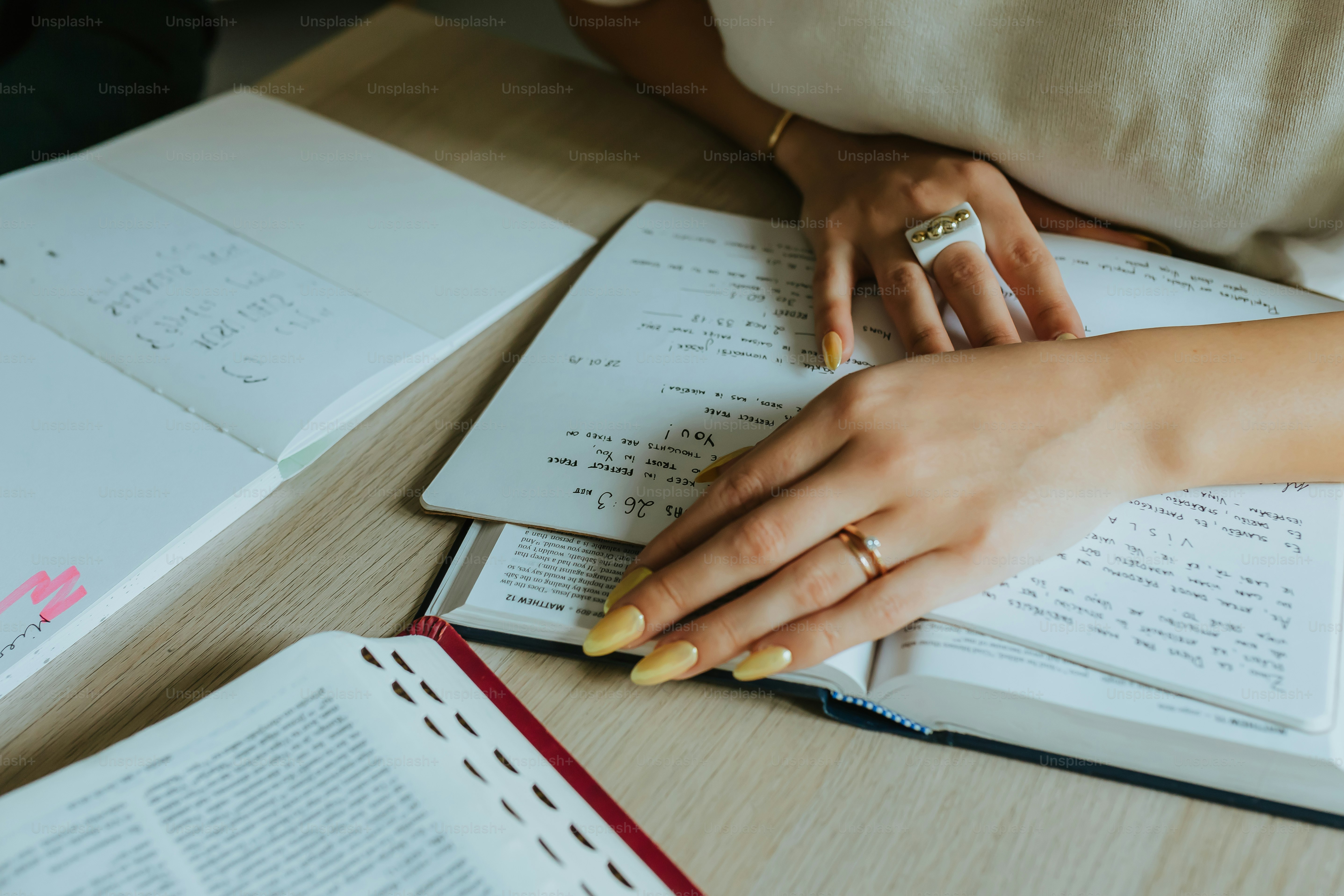 女性が本のあるテーブルに座っている