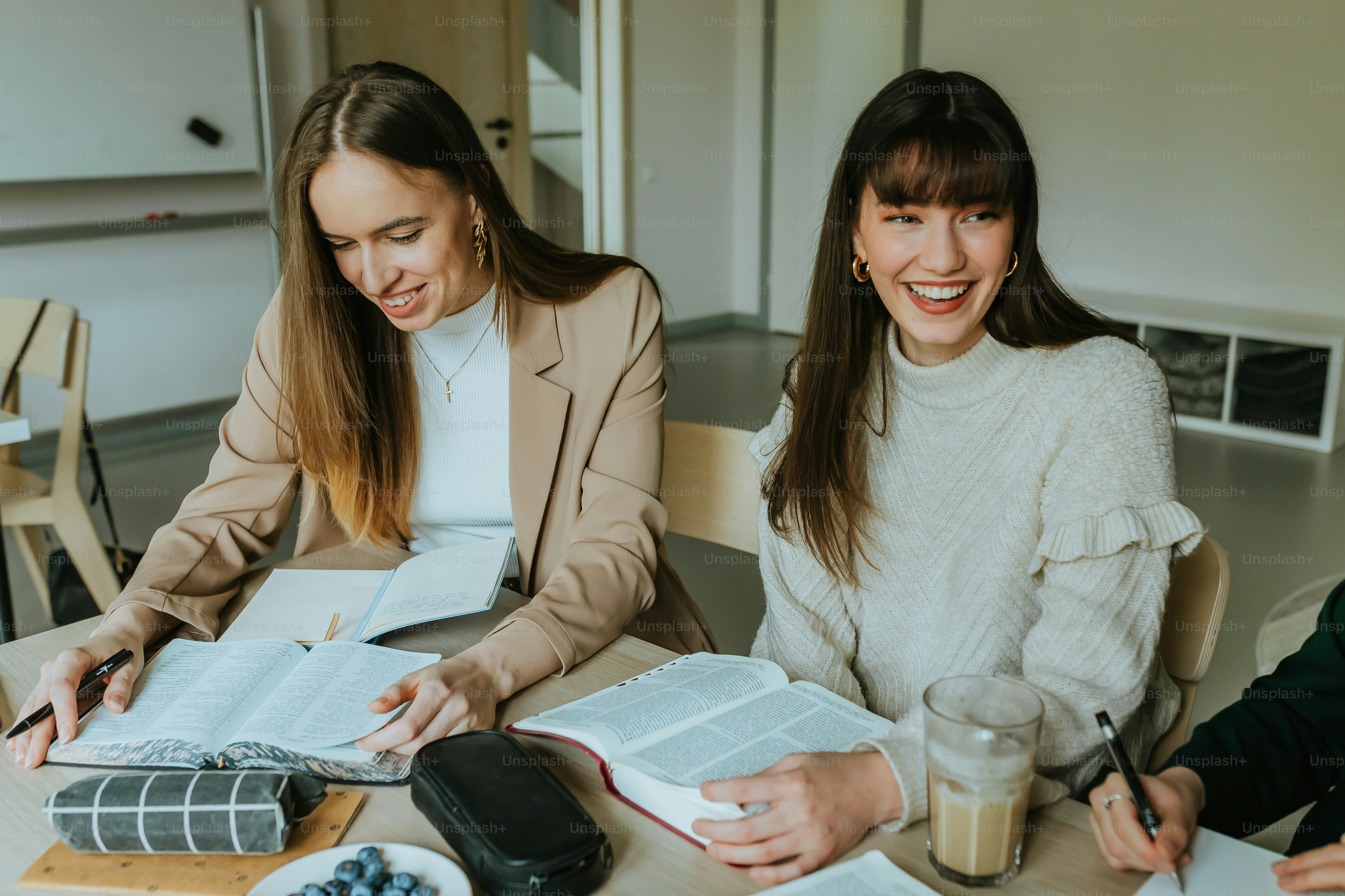 ノートと書類を置いたテーブルに座る3人の女性