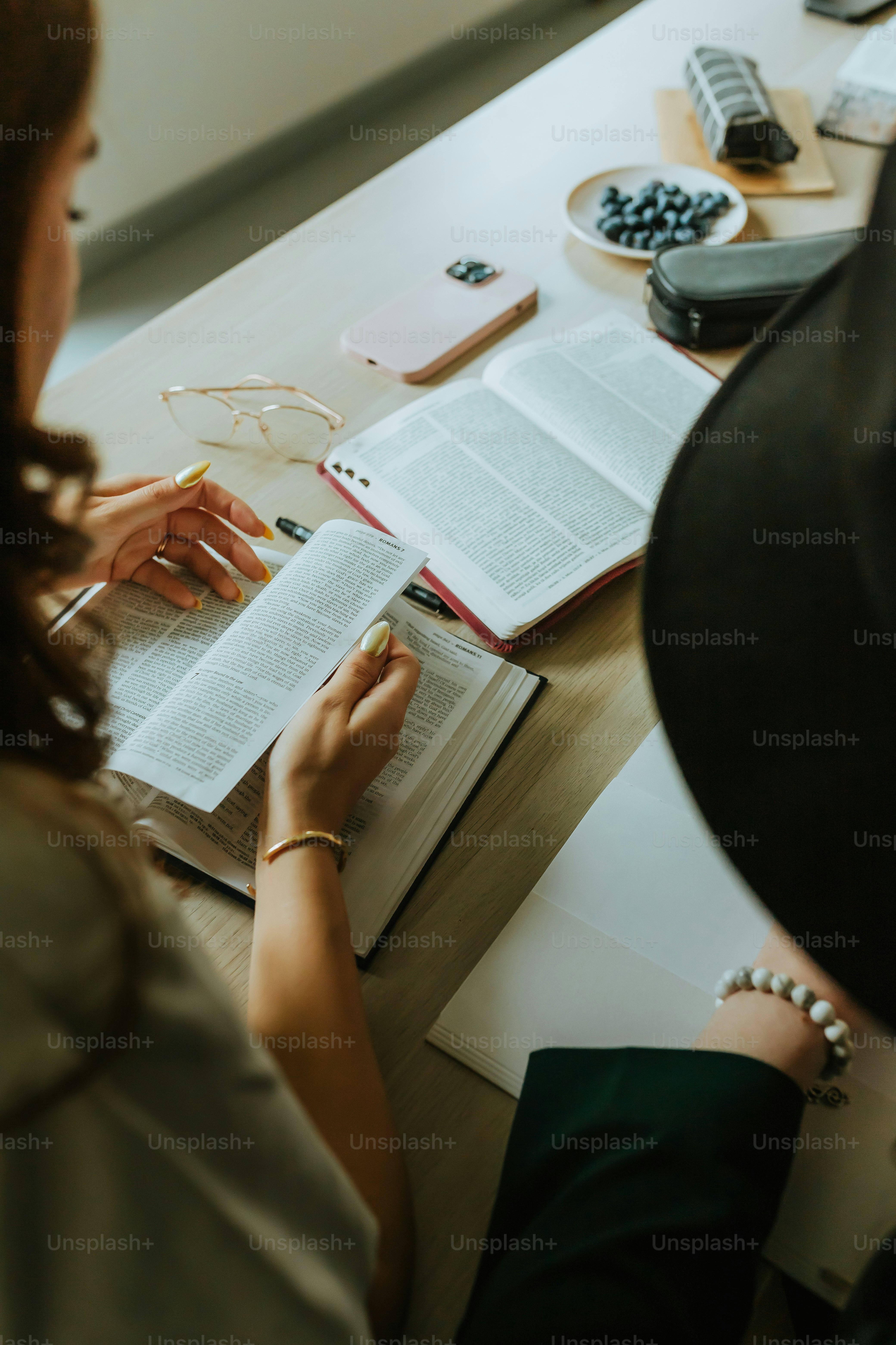 a woman sitting at a table with an open book
