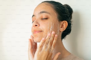 una donna che si lava il viso con un sacco di sapone