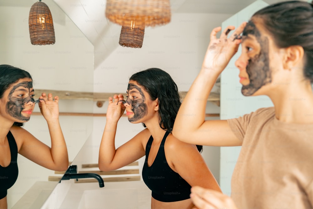 a woman with a face mask is looking in the mirror