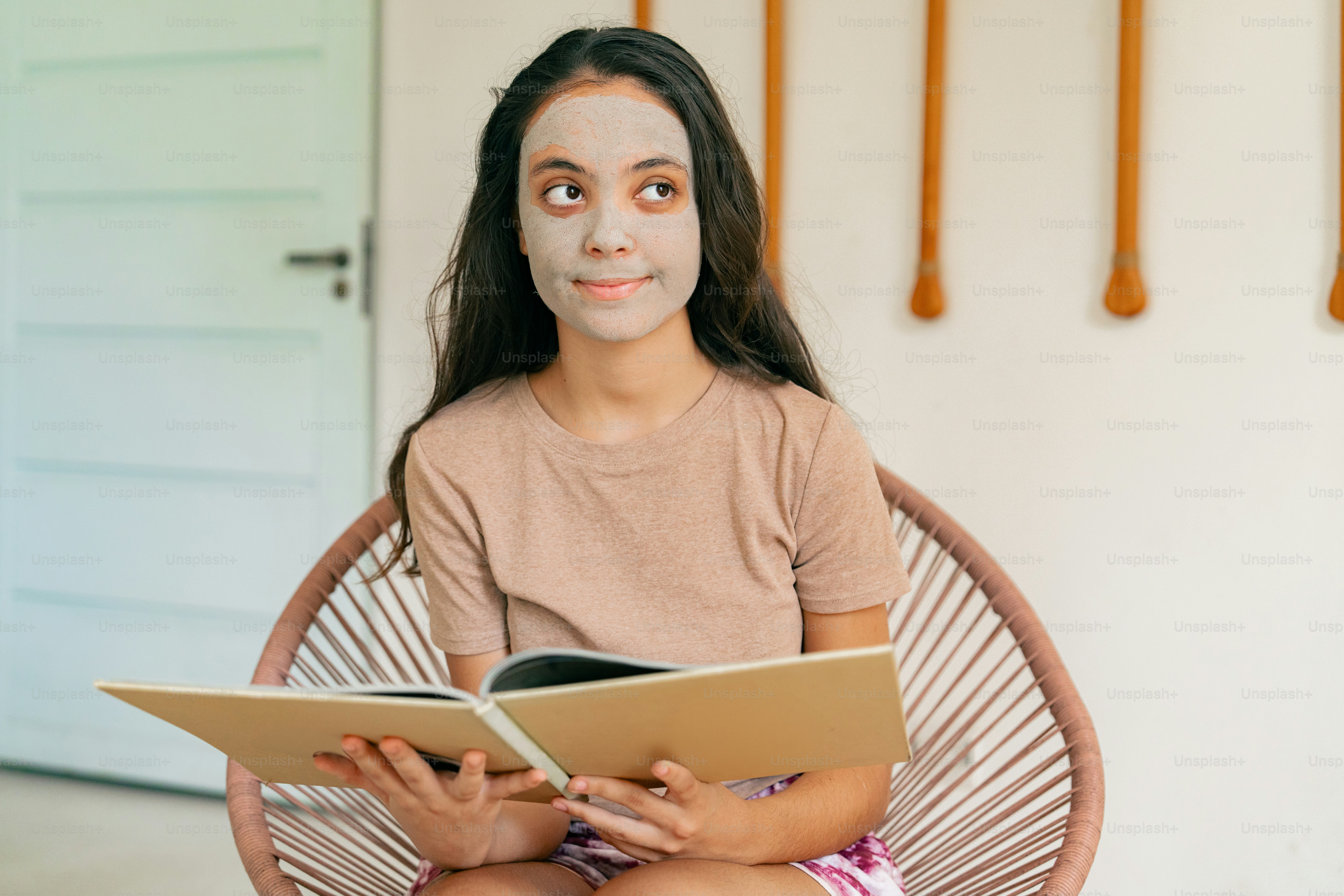 A girl sitting in a chair reading a book photo – Teen Image on Unsplash