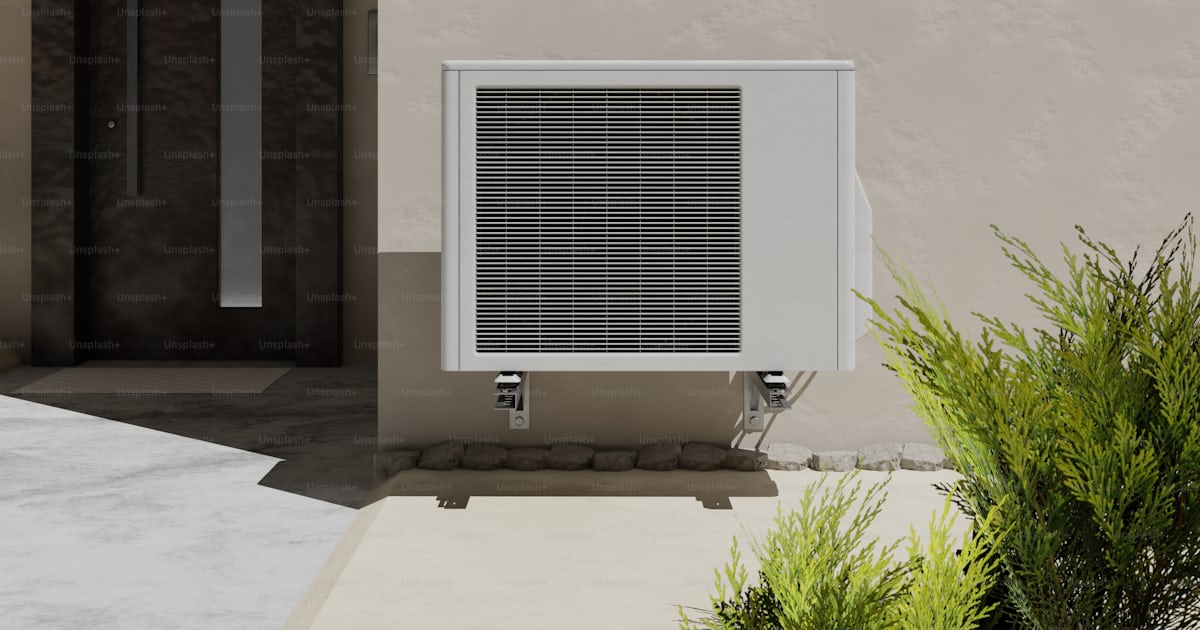 A small air conditioner sitting outside of a building photo ...