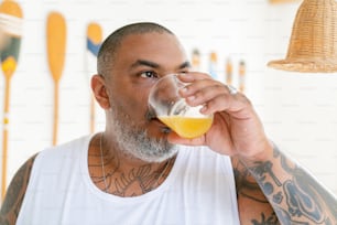 a man drinking a glass of orange juice