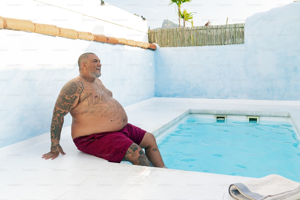 a man with tattoos sitting in a pool