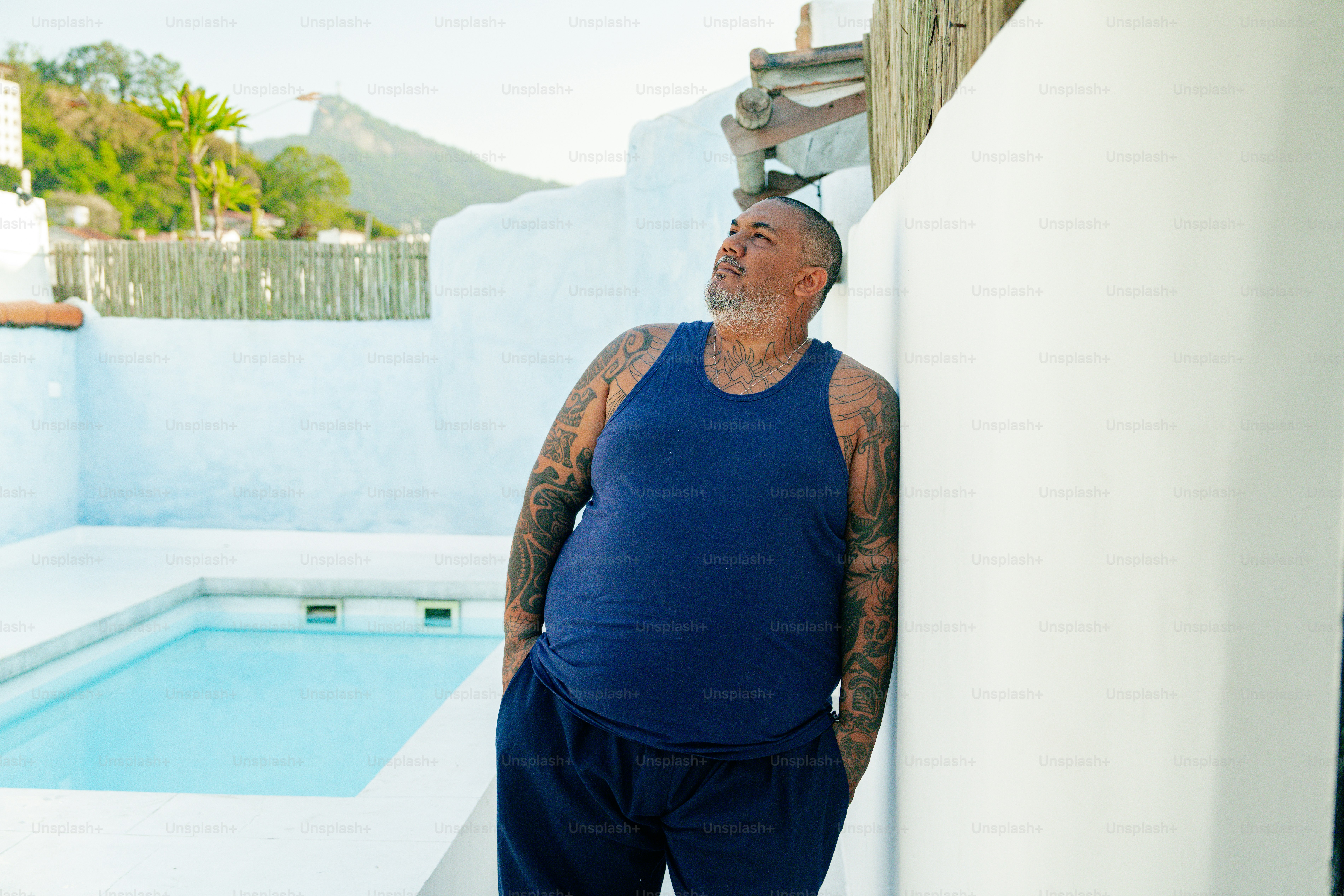 a man leaning against a wall next to a pool
