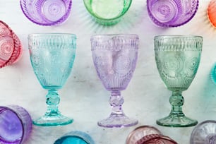 um grupo de taças de vidro coloridas sentadas em cima de uma mesa