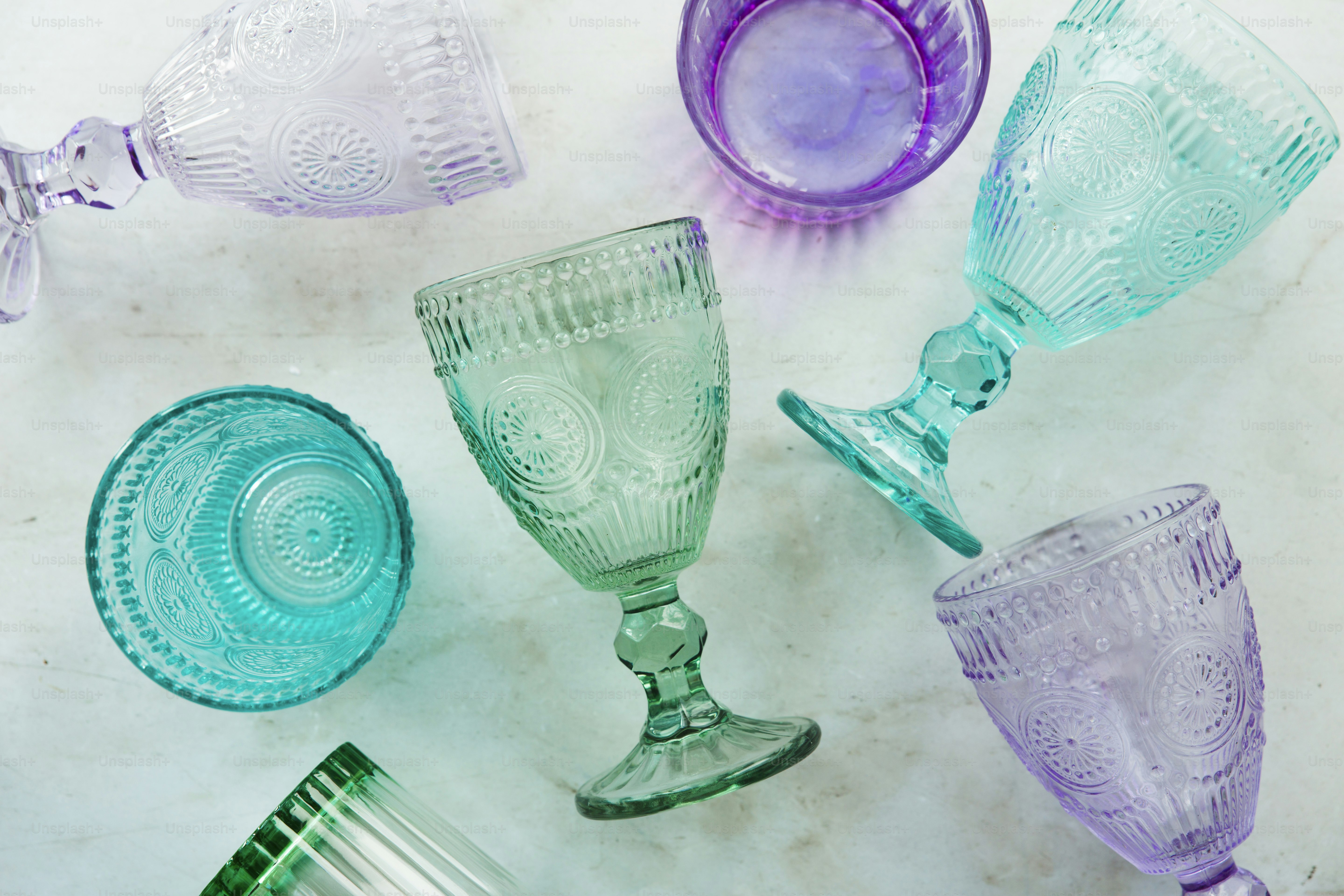 une table surmontée de nombreux verres de couleurs différentes