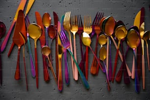 a group of forks and spoons lined up on a wall