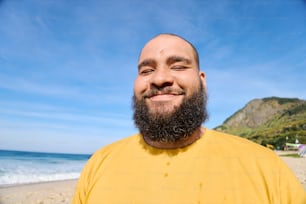 un uomo con la barba in piedi su una spiaggia
