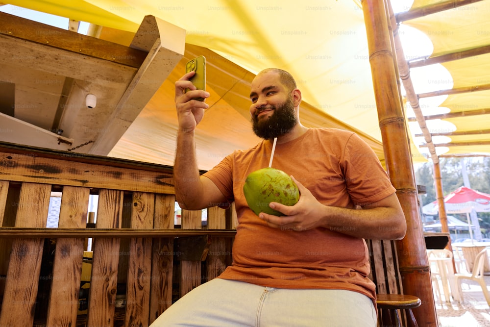 a man sitting on a bench holding a green apple