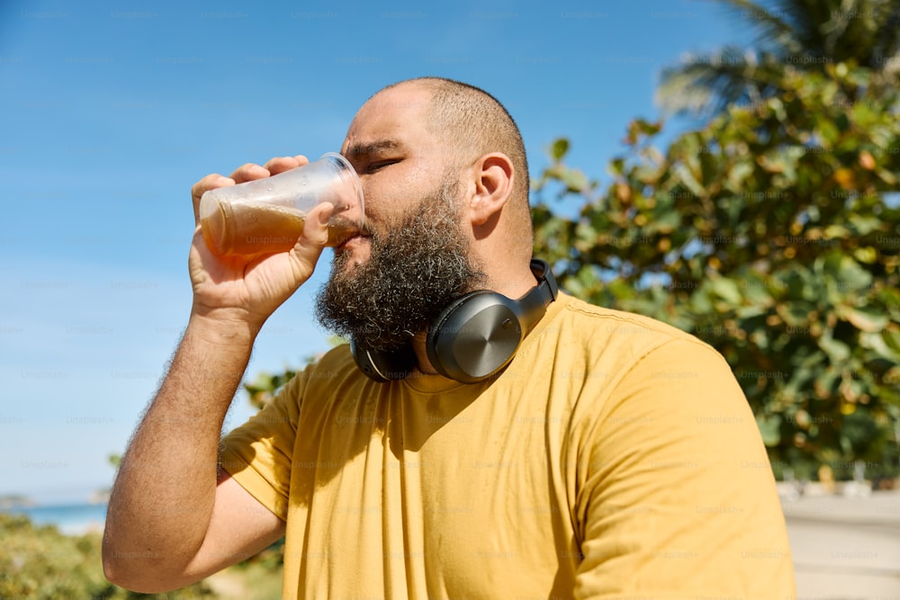 a man with a beard drinking from a glass