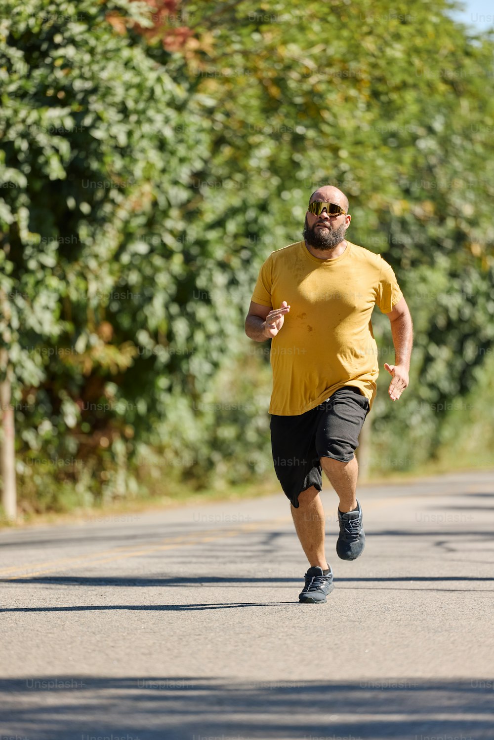 a man in a yellow shirt running down a street