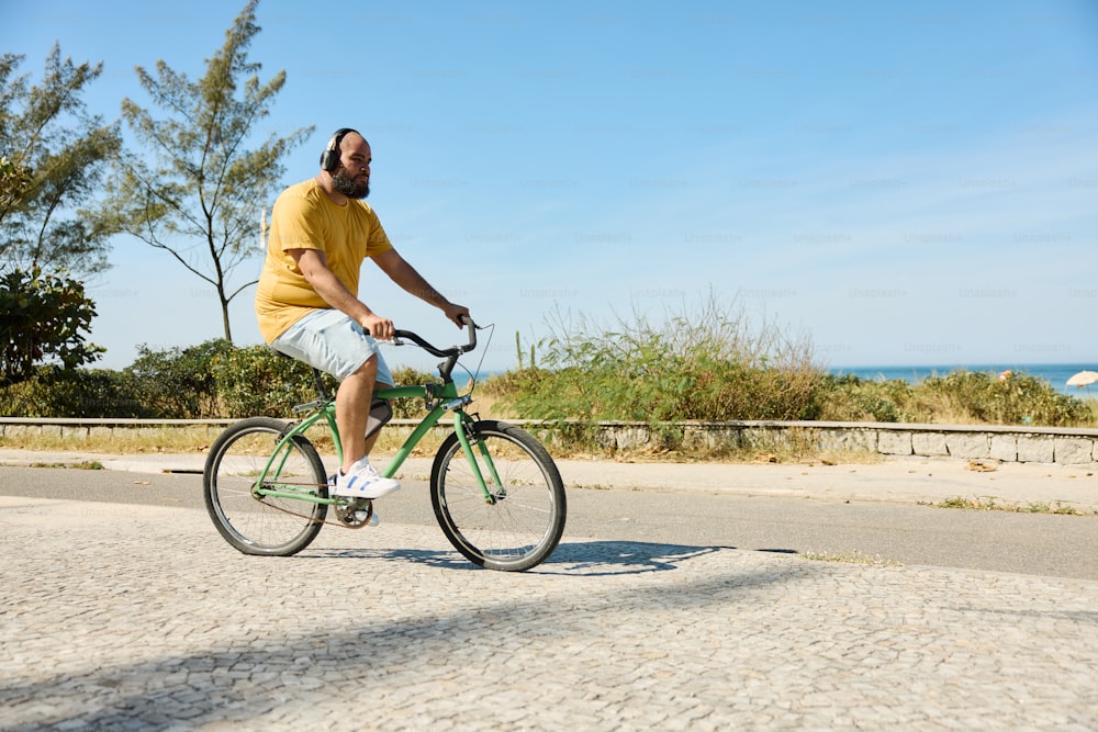 a man riding a bike down a street next to the ocean