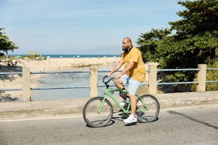 a man riding a green bike down a street